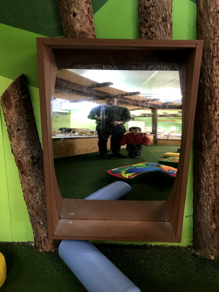 Tim and Max in a distorting mirror at the playground at the Indoor Apenkooien hall at the Dierenrijk zoo
