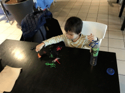 Max playing with animal toys at Restaurant Smulrijk at the Dierenrijk zoo