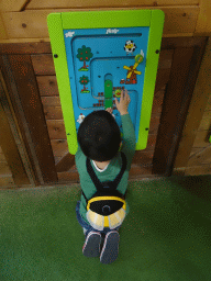 Max doing a puzzle at the playground at the Indoor Apenkooien hall at the Dierenrijk zoo