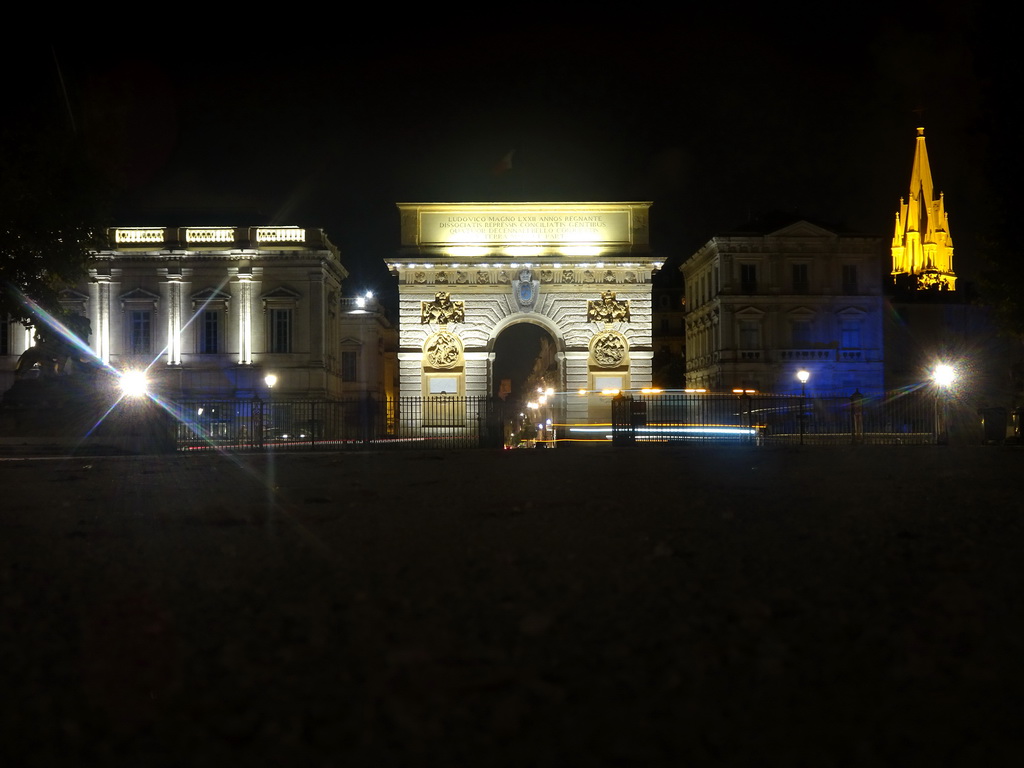 Back side of the Porte du Peyrou arch and the tower of the Église Sainte Anne church, viewed from the Promenade du Peyrou, by night