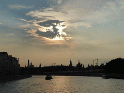 Sun behind the clouds above the Moskva river and the towers of the Moscow Kremlin and Saint Basil`s Cathedral, viewed from the tour boat