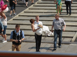 Bride and groom at a wedding party at the Luzhkov Bridge over the Vodootvodny Canal, viewed from the sightseeing bus