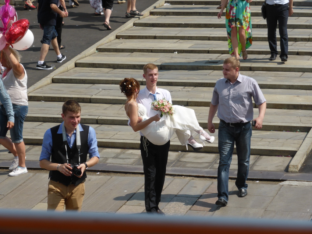 Bride and groom at a wedding party at the Luzhkov Bridge over the Vodootvodny Canal, viewed from the sightseeing bus