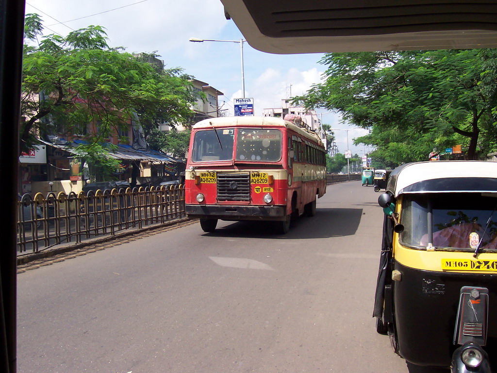 Rickshaw and a bus on a central street