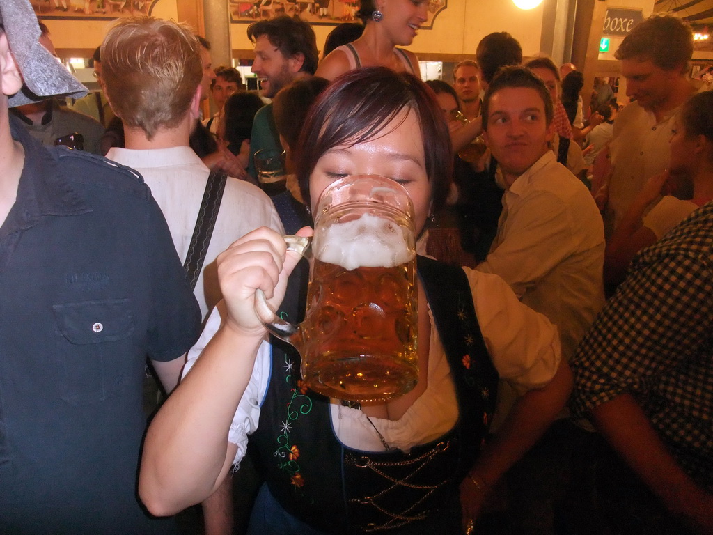 Miaomiao with a beer, and people celebrating the Oktoberfest festival in the Paulaner tent at the Oktoberfest terrain at the Theresienwiese square