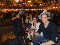 Tim, Miaomiao and friends with beers, and people celebrating the Oktoberfest festival in the Paulaner tent at the Oktoberfest terrain at the Theresienwiese square
