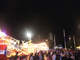 Funfair at the Oktoberfest terrain at the Theresienwiese square and St. Paul`s Church, by night