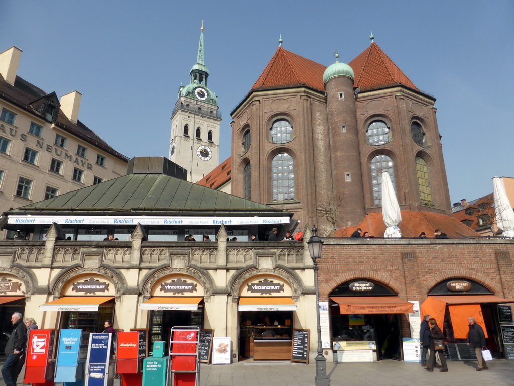 Shops at the Viktualienmarkt square, with a view on the tower and back side of St. Peter`s Church