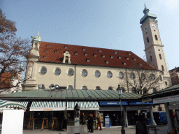 Fountain and market stalls at the Viktualienmarkt square, and the tower and south side of the Heiliggeistkirche church