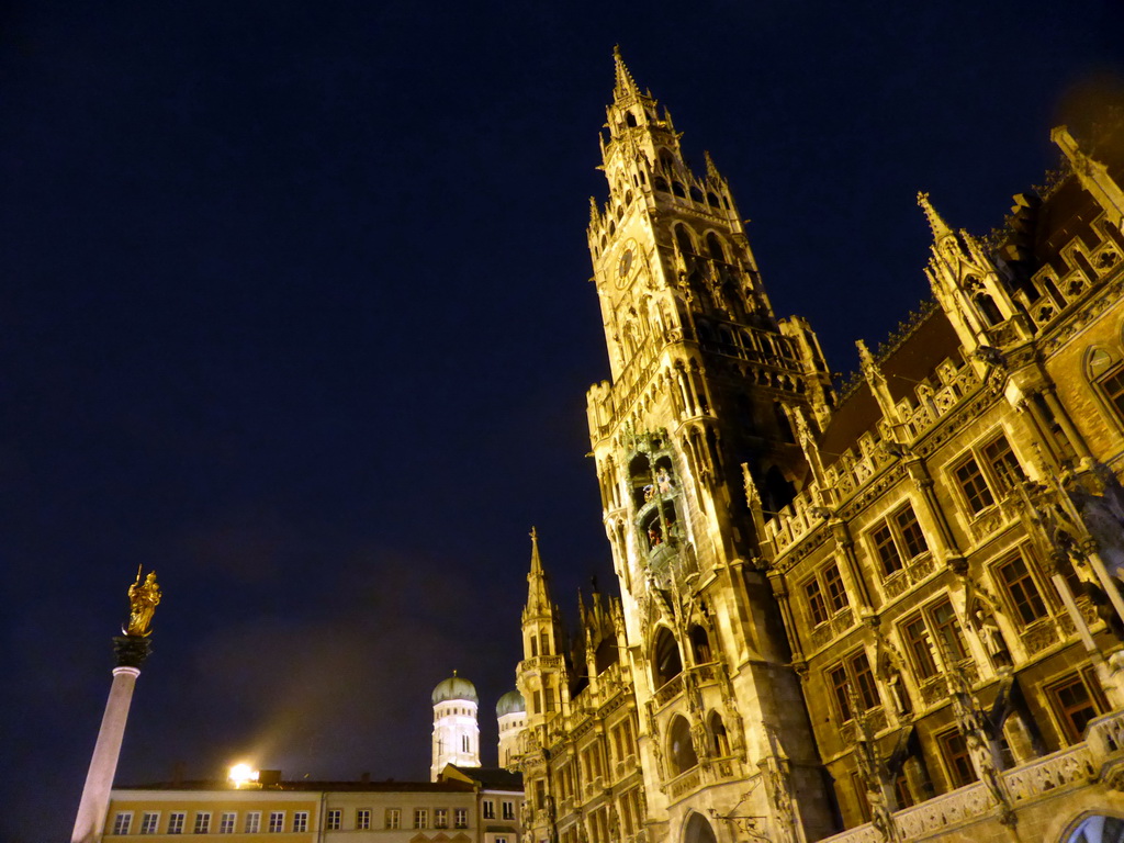 The Mariensäule column, the towers of the Frauenkirche church and the left front and tower of the the Neues Rathaus building, viewed from the Marienplatz square, by night