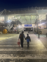 Miaomiao and Max walking to the Arrivals Hall of Naples International Airport, by night