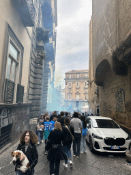The Vico San Domenico Maggiore street with the northeast side of the Chiesa di San Domenico Maggiore church and SSC Napoli football fans at the Piazza San Domenico Maggiore square