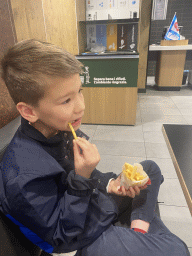 Max eating fries at the McDonald`s restaurant at the Doganella Nord service area