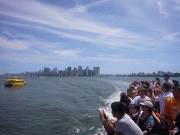 The skyline of Manhattan, a boat and people on the ferry, from the Liberty Island ferry