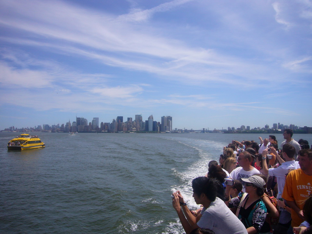 The skyline of Manhattan, a boat and people on the ferry, from the Liberty Island ferry