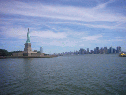 The Statue of Liberty, the skyline of Manhattan and a boat, from the Liberty Island ferry