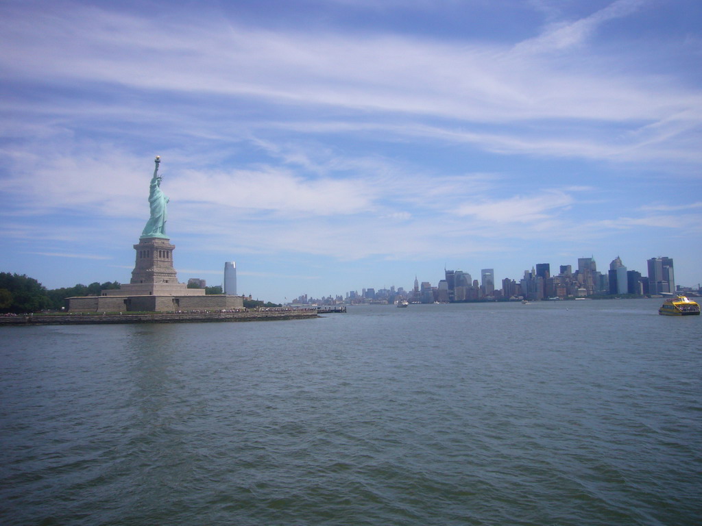 The Statue of Liberty, the skyline of Manhattan and a boat, from the Liberty Island ferry