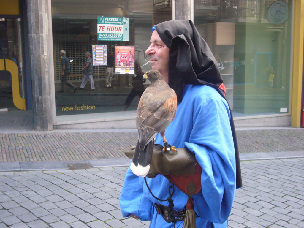 Person in medieval clothes and a falcon at the Houtstraat street, during the Gebroeders van Limburg Festival