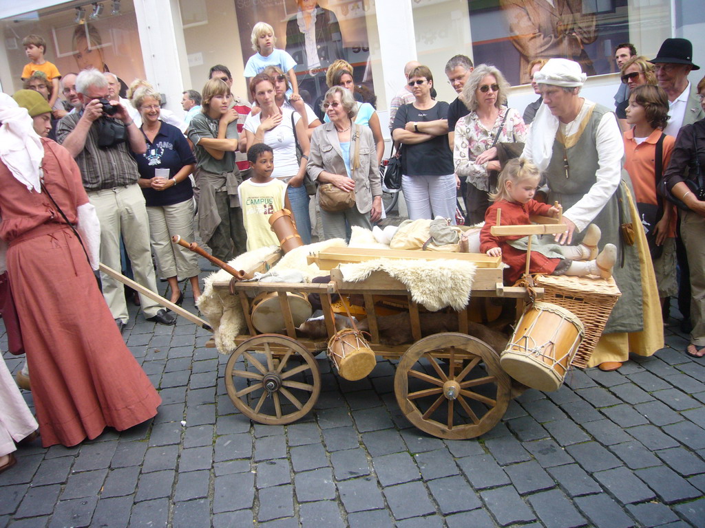 People in medieval clothes and a cart at the Houtstraat street, during the Gebroeders van Limburg Festival