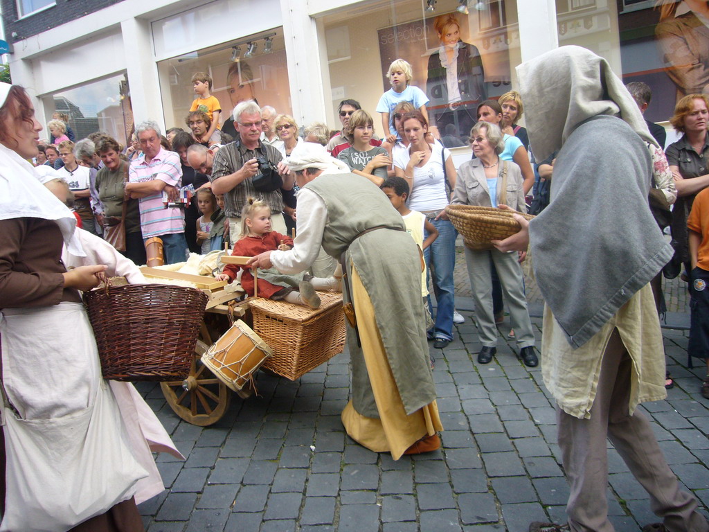 People in medieval clothes and a cart at the Houtstraat street, during the Gebroeders van Limburg Festival