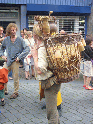 Person in medieval clothes carrying stuff on his back at the Houtstraat street, during the Gebroeders van Limburg Festival