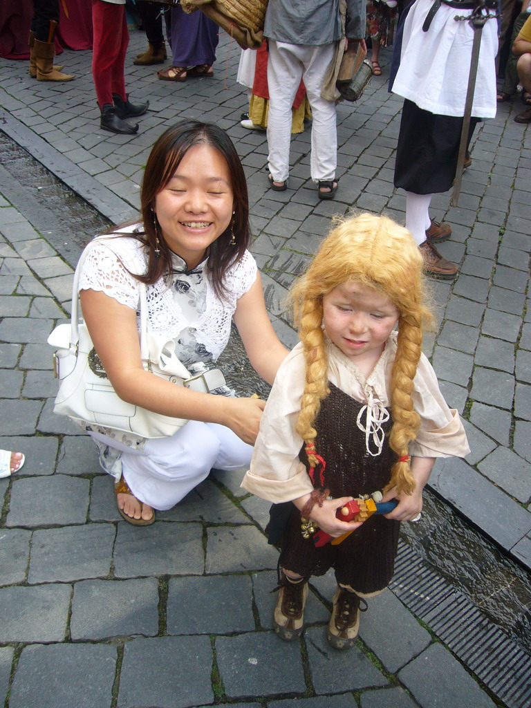 Miaomiao with a child in medieval clothes at the Houtstraat street, during the Gebroeders van Limburg Festival