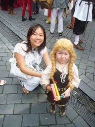 Miaomiao with a child in medieval clothes at the Houtstraat street, during the Gebroeders van Limburg Festival