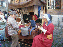 Person in medieval clothes making clothes at the Sint Stevenskerkhof square, during the Gebroeders van Limburg Festival