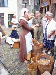 Person in medieval clothes selling food at the Sint Stevenskerkhof square, during the Gebroeders van Limburg Festival