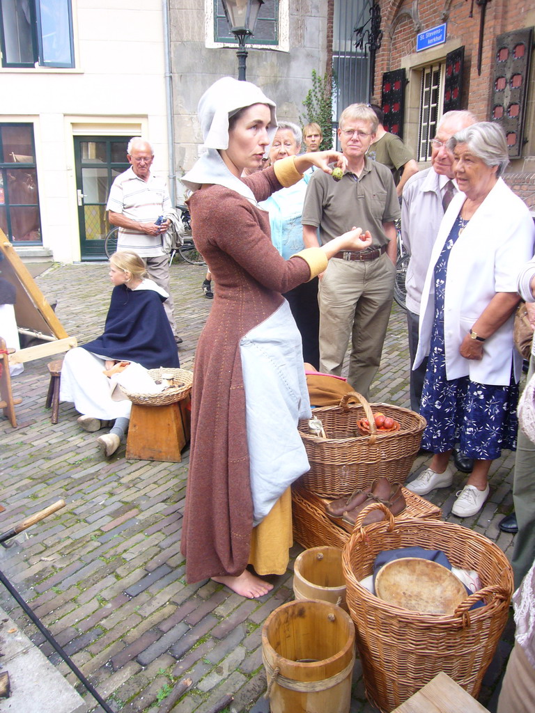 Person in medieval clothes selling food at the Sint Stevenskerkhof square, during the Gebroeders van Limburg Festival