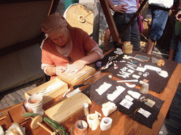 Person in medieval clothes making jewellery at the Sint Stevenskerkhof square, during the Gebroeders van Limburg Festival