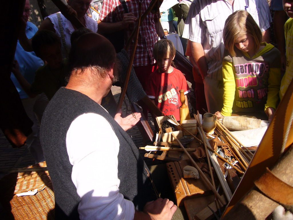 Person in medieval clothes making arrows at the Sint Stevenskerkhof square, during the Gebroeders van Limburg Festival
