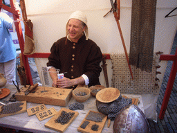 Person in medieval clothes making armour at the Sint Stevenskerkhof square, during the Gebroeders van Limburg Festival