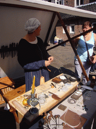 Person in medieval clothes making jewellery at the Sint Stevenskerkhof square, during the Gebroeders van Limburg Festival