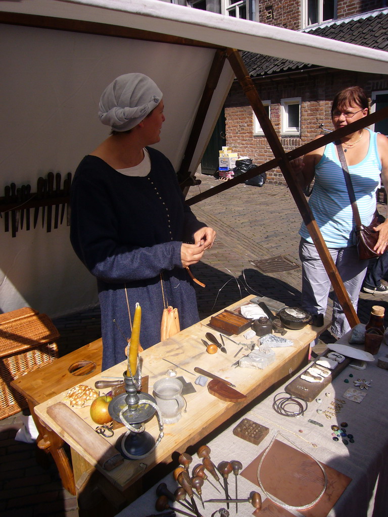 Person in medieval clothes making jewellery at the Sint Stevenskerkhof square, during the Gebroeders van Limburg Festival