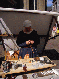 Person in medieval clothes making jewellery at the Sint Stevenskerkhof square, during the Gebroeders van Limburg Festival