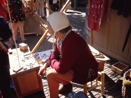 Person in medieval clothes making jewellery at the Sint Stevenskerkhof square, during the Gebroeders van Limburg Festival