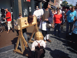 People in medieval clothes with a pillory at the Broerstraat street, during the Gebroeders van Limburg Festival