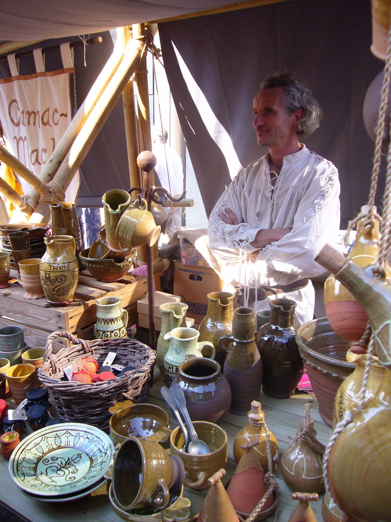 Person in medieval clothes selling pottery at the Broerstraat street, during the Gebroeders van Limburg Festival