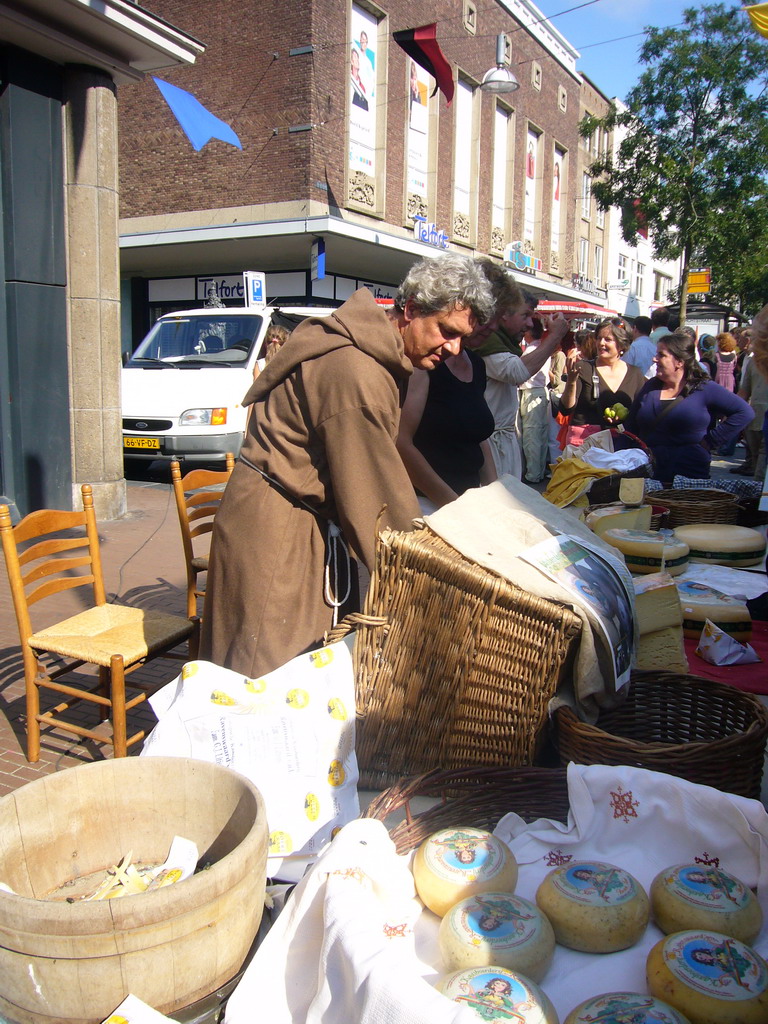 Person in medieval clothes selling cheese at the Broerstraat street, during the Gebroeders van Limburg Festival