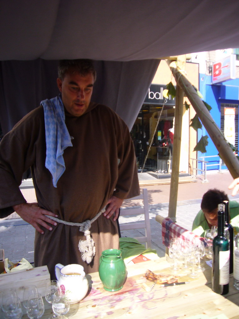 Person in medieval clothes selling wine at the Broerstraat street, during the Gebroeders van Limburg Festival