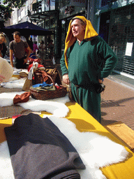 Person in medieval clothes selling clothes at the Broerstraat street, during the Gebroeders van Limburg Festival