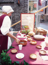 Person in medieval clothes selling bread at the Broerstraat street, during the Gebroeders van Limburg Festival
