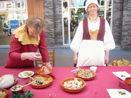 People in medieval clothes selling bread at the Broerstraat street, during the Gebroeders van Limburg Festival