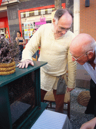 Person in medieval clothes showing honey bees at the Broerstraat street, during the Gebroeders van Limburg Festival