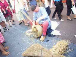 Person in medieval clothes making rush baskets at the Broerstraat street, during the Gebroeders van Limburg Festival