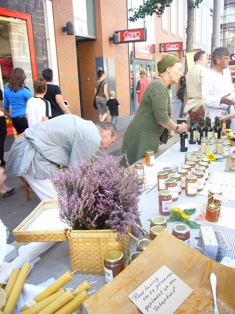 People in medieval clothes selling honey at the Broerstraat street, during the Gebroeders van Limburg Festival