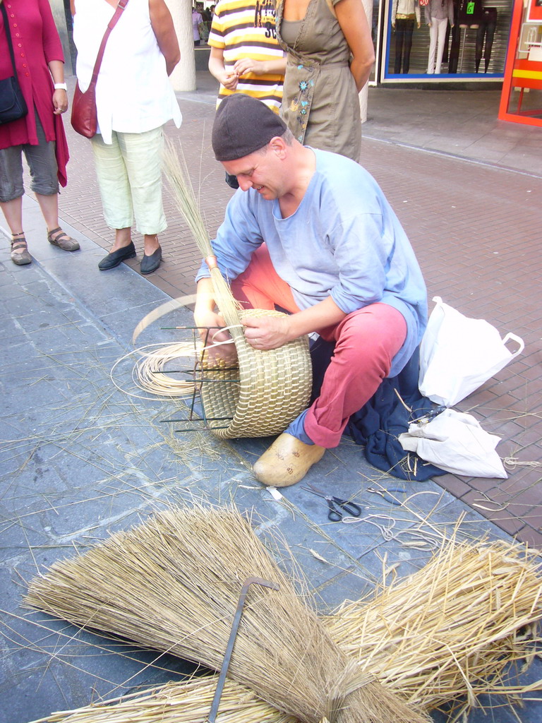 Person in medieval clothes making rush baskets at the Broerstraat street, during the Gebroeders van Limburg Festival