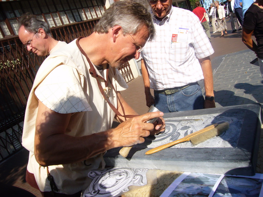 Person in medieval clothes making art at the Broerstraat street, during the Gebroeders van Limburg Festival