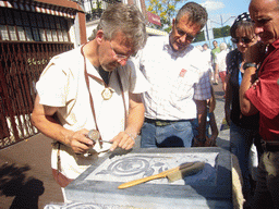 Person in medieval clothes making art at the Broerstraat street, during the Gebroeders van Limburg Festival